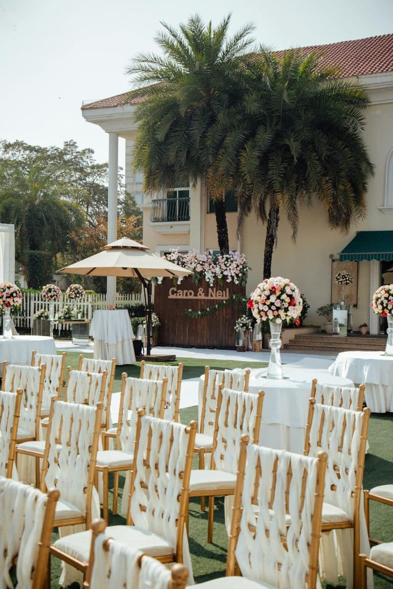 An elegant outdoor wedding setup with chairs, flowers, and decorations.