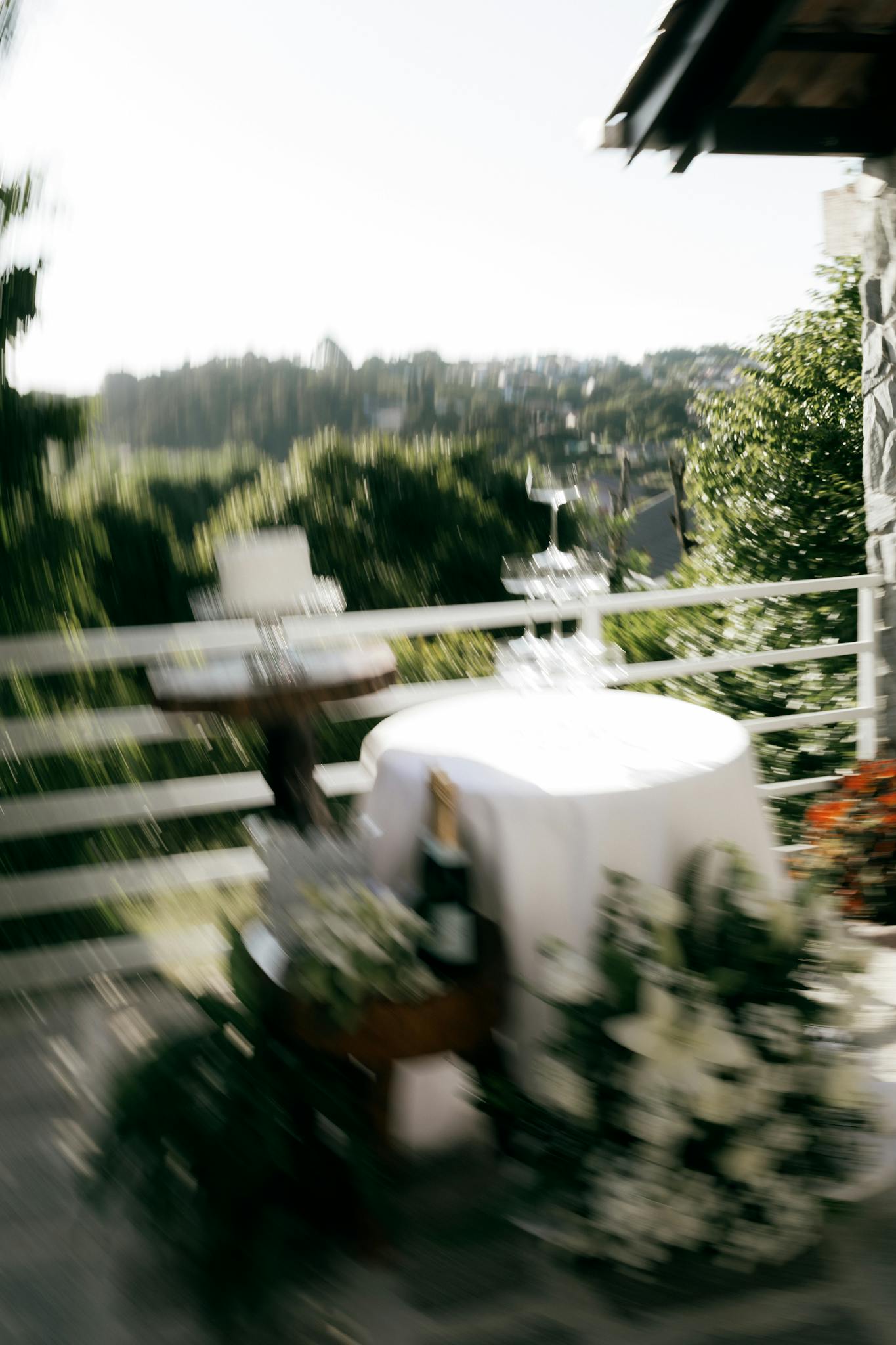 Blurred outdoor scene of a wedding reception setup with cake, table, and champagne.