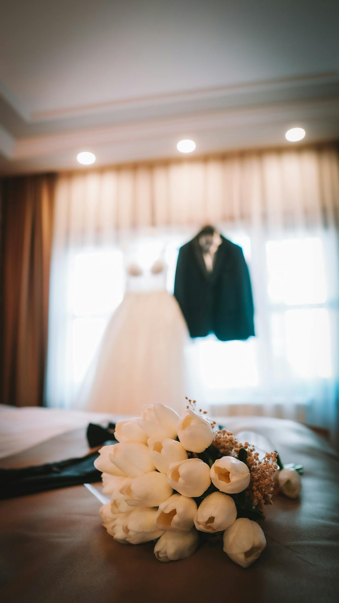 Elegant wedding dress with a bouquet on bed, perfect for special day themes.